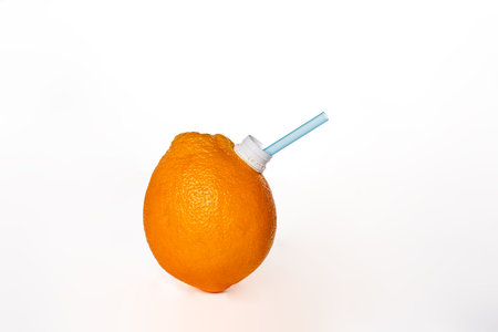 Orange, fruit on a white background, with a straw in the spout to be able to drink like a juice bottle.の写真素材