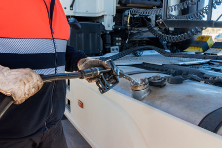 Truck driver with a pump nozzle in his hands filling the vehicle's fuel tank.の写真素材