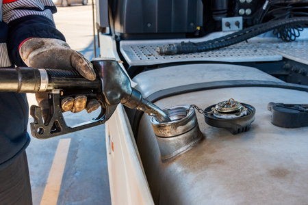 Truck driver with a pump nozzle in his hands filling the vehicle's fuel tank.の写真素材