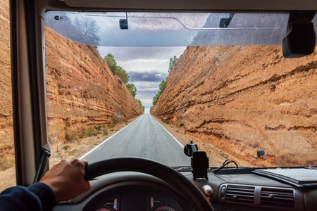 View from the driving position of a truck driving on a narrow road between two cuts dug into the ground.の写真素材