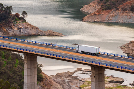 Truck with a refrigerated semi-trailer driving through a viaduct.の写真素材