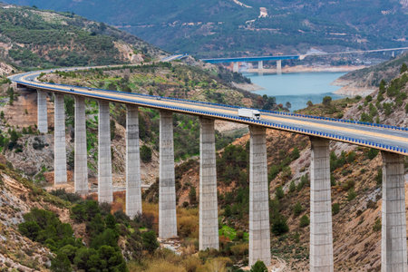 Refrigerated truck driving on a highway with bridges over a swamp, road landscape in the mountains.の写真素材
