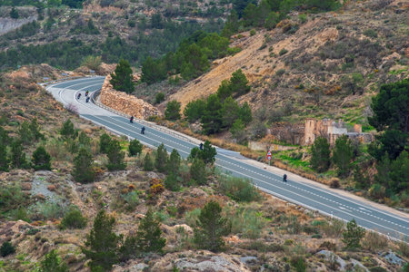 Several motorcycles circulating on a two-way road and with a curve in the mountains.の写真素材