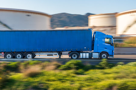 Truck with sliding canvas for general transport circulating along a road, sweeping effect.の写真素材