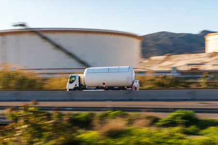 Small tank truck for the transport of dangerous gases circulating on a road, side view.の写真素材