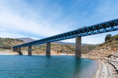 Metallic bridge with concrete bases over the Rules reservoir in Grenada, with a refrigerated truck circulating.の写真素材