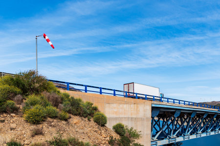 Windsock located at the entrance to a bridge where a truck circulates.の写真素材
