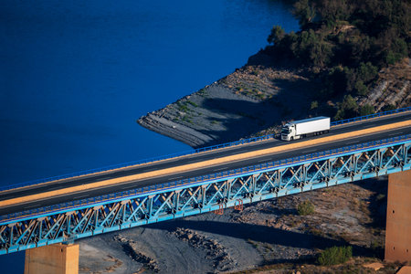 Truck with a refrigerated trailer driving on a metal bridge.の写真素材