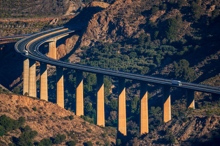 Two refrigerated trucks driving on a viaduct at dawn.の写真素材