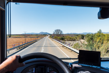 View from the driver's position of a truck of a conventional two-way road between cultivated fields.の写真素材