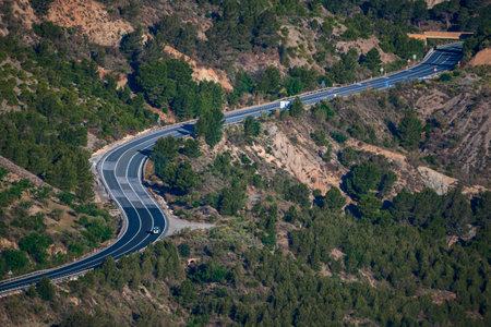 Police traffic control vehicle driving on a winding mountain road.の写真素材