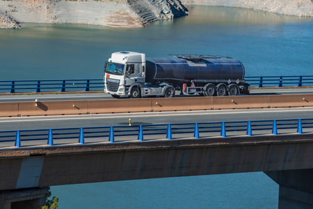 Tanker truck for the transport of dangerous goods circulating on a bridge over a swamp.の写真素材