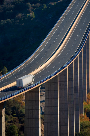 Truck with semi-trailer for general cargo driving through a viaduct with a lot of height over a ravine.の写真素材