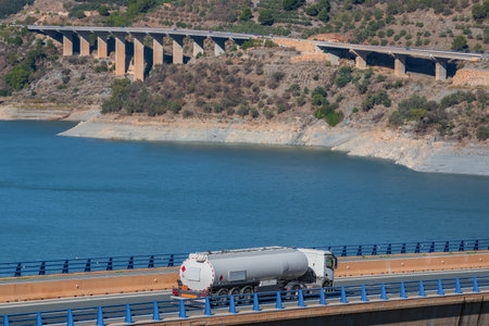 Tanker truck for the transport of fuels circulating on a bridge, in the background several more viaducts. Landscape.の写真素材