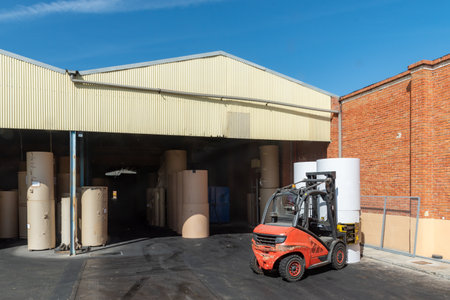 Forklift with clamps to move reels of paper in a warehouse.の写真素材