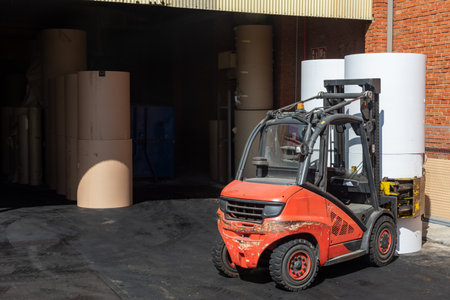 Forklift with clamps to move reels of paper in a warehouse.の写真素材
