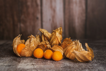 Still life of physalis on a brown wooden background.の写真素材