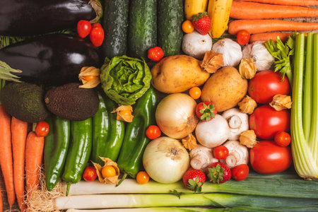 Background created with fruits and vegetables,cucumbers,eggplants,potatoes,peppers,garlic,mushrooms,lettuce,carrots,leek,celery,strawberries,physalis,tomatoes,avocados and cucumber.の写真素材