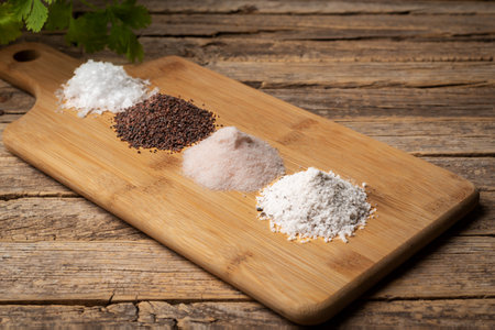 Wooden table with lots of different types of salt, black, pink, flakes and seasoned with truffles.の写真素材