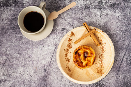 Pasteis de nata, also called de Belem, typical sweet from Lisbon, Portugal, next to a cup of coffee.の写真素材
