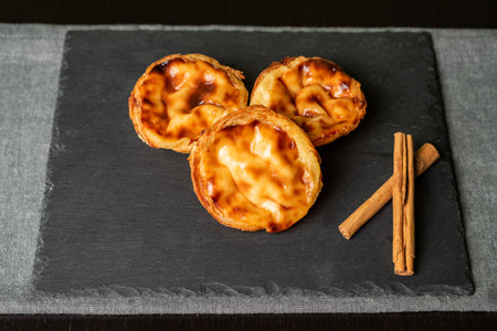 Pasteis de nata, is a typical sweet from Lisbon, Portugal, several pastries on a stone plate.の写真素材