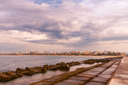 The coastal city of Portimao seen from the breakwater of Praia da Rocha beach, Algarve.の写真素材