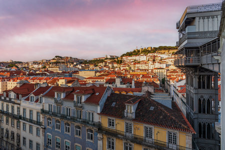 View of the Santa Justa elevator next to old buildings, with the castle of Saint George in the background, Lisbon.のeditorial素材