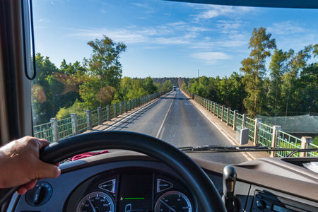 View from the driving position of a truck of a conventional two-way road over a narrow bridge where another truck is traveling in the opposite direction. .の写真素材