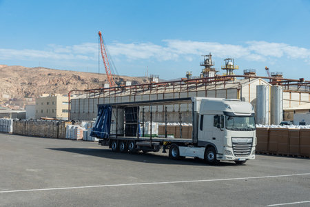 Truck with the side canvases open and empty waiting to be loaded with pallets with peat.の写真素材
