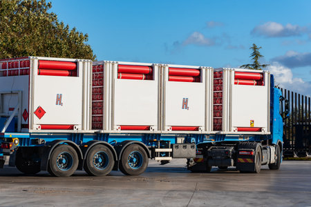 Truck with bottles connected to each other for the transport of hydrogen, H2, with a red label with a flame.の写真素材