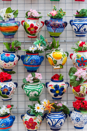 Many flower pots hung and decorated, with flowers inside creating a multicolored pattern.