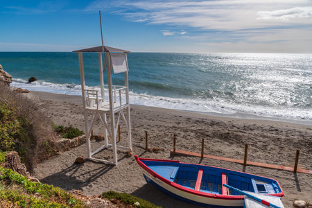 Watchtower and small decorative boat on Carabeo beach in the municipality of Nerja.の写真素材