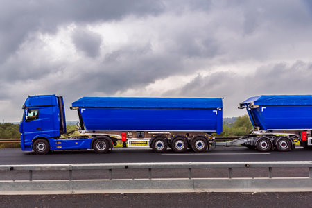 Truck with two semi-trailers attached, commonly called Duo-trailer, traveling on a highway.の写真素材