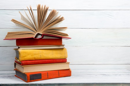 Open book, hardback books on wooden table. Back to school. Copy space.