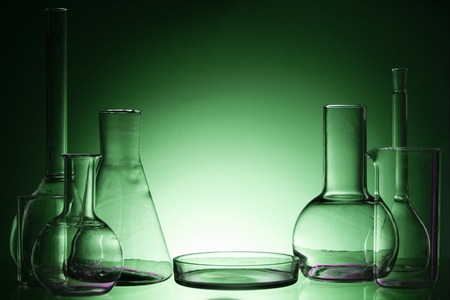 Assorted empty laboratory glassware, test-tubes. Green tone medical background. Copy space for textの写真素材