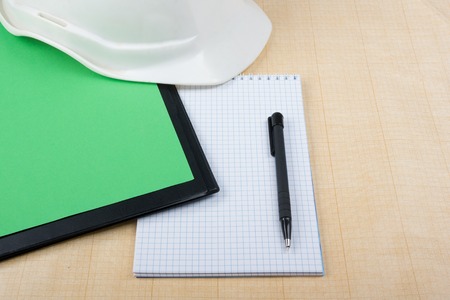Workplace of architect - Architectural project, plan, blueprint rolls and pen, safety helmet on blank sheet of paper. Engineering tools view from the top. Construction background. Copy spaceの写真素材