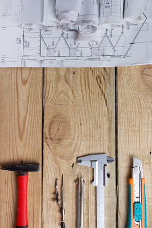 Architectural project, blueprints, blueprint rolls and divider compass, calipers on vintage wooden background. Construction concept. Engineering tools. Copy space.の写真素材