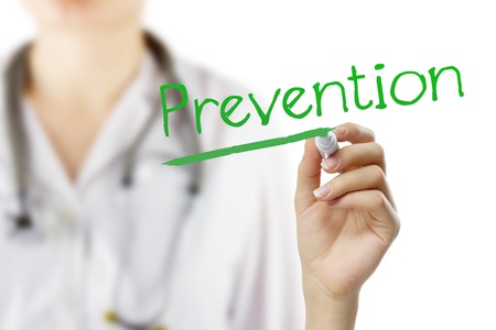 Female doctor with stethoscope writing  Prevention . Hand holding pen isolated on white. Medical backgroundの写真素材