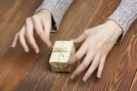 Present,  gift. Close up of female hands holding small gift.の写真素材