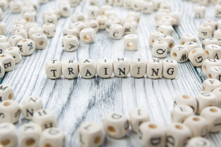Training text on a wood blocks at wooden background.の写真素材