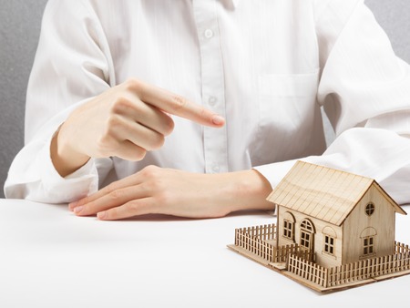 Real estate concept - businessman behind home architectural model.の写真素材
