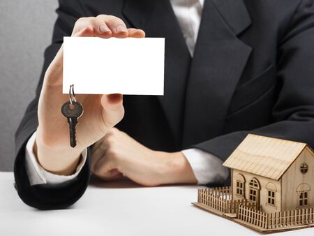 Hands holding blank business card with keys. Real estate concept.の写真素材