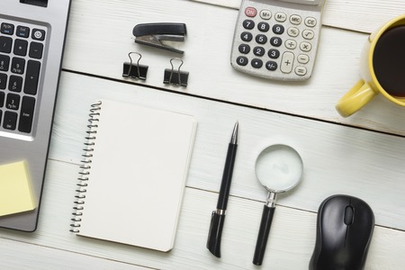 Office desk table with supplies and coffee cup. Top view. Copy space for text.の写真素材