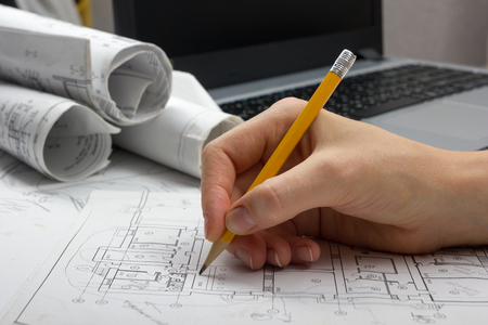 Architect working on blueprint. Architects workplace - architectural project, blueprints, ruler, calculator, laptop and divider compass. Construction concept. Engineering tools.の写真素材