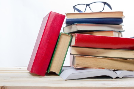 Stack of books on wooden shelf isolated on white background. Back to school. Copy space for text.の写真素材