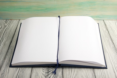 Open book with blank pages on textured wood background. Copy space.の写真素材