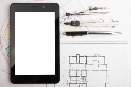 Workplace of architect - Architectural project, blueprints, rolls and tablet, pen, divider compass on plans. Engineering tools view from the top. Construction background. Copy space for textの写真素材