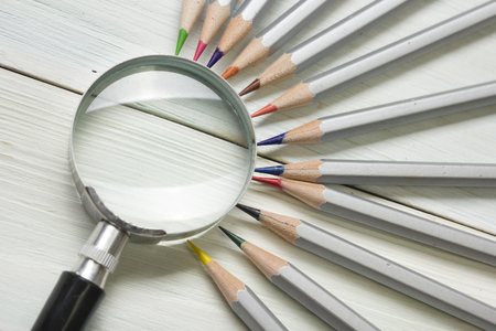magnifying glass, pencils and blank business card on wooden table. Copy space for text.の写真素材