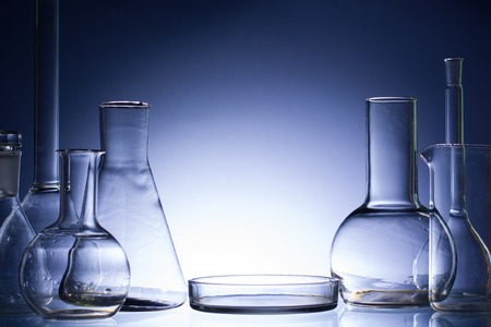 Assorted empty laboratory glassware, test-tubes. Blue tone medical background. Copy space for text