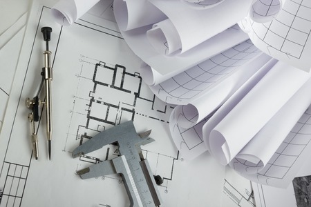 Workplace of architect - Architectural project, blueprints, rolls and tablet, pen, divider compass on plans. Engineering tools view from the top. Construction background. Copy space for textの写真素材